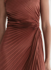 woman wearing strapless pleated gown in a rust hue