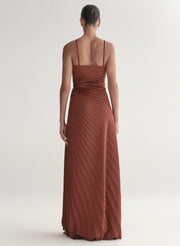 woman wearing strapless pleated gown in a rust hue