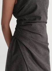 Woman wearing a dark grey one-shoulder mini dress on a white background
