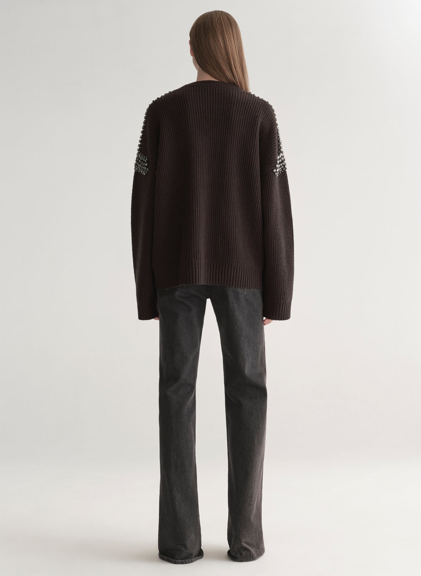 woman wearing brown embellished sweater with black denim jeans