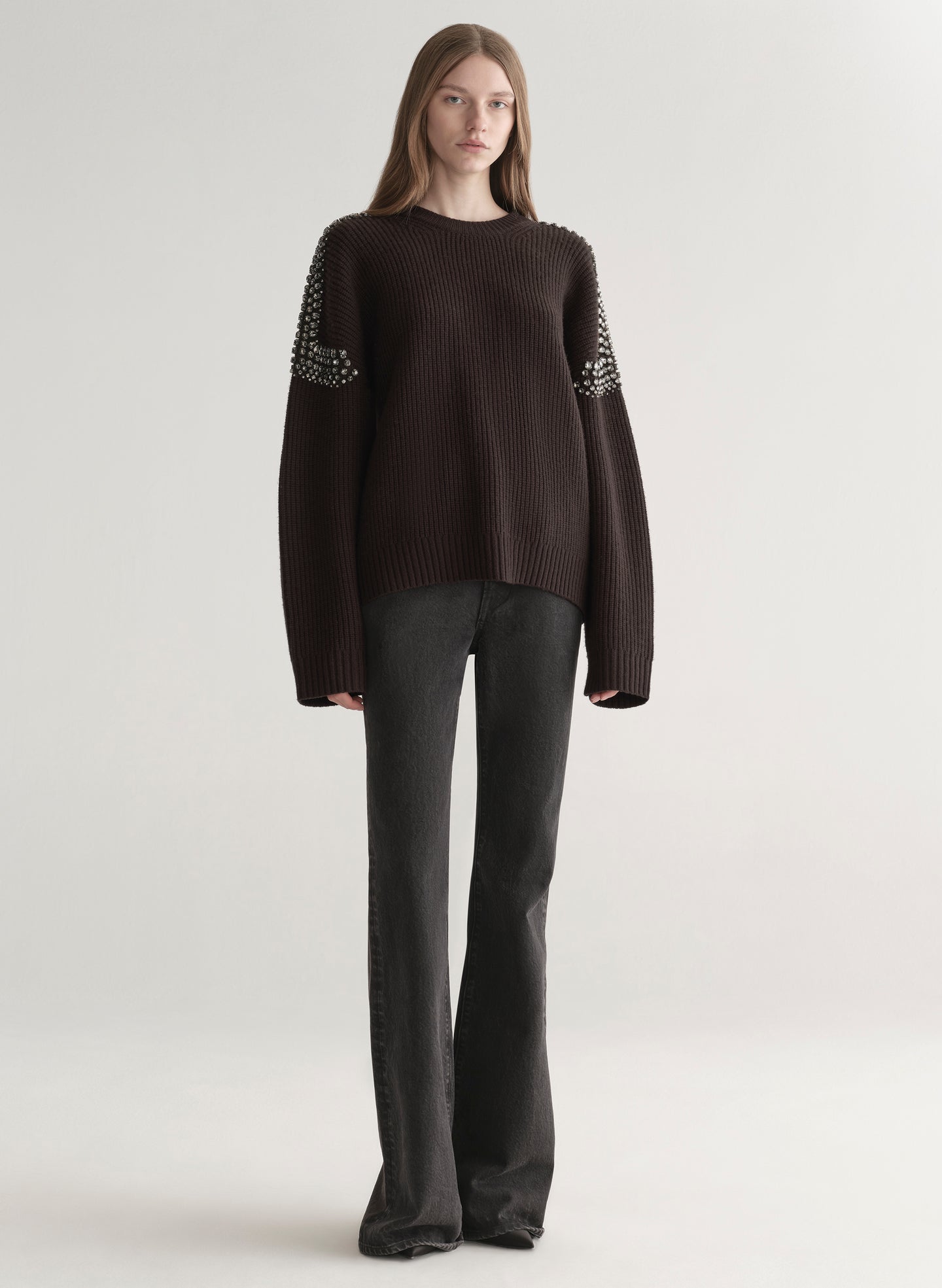 woman wearing brown embellished sweater with black denim jeans