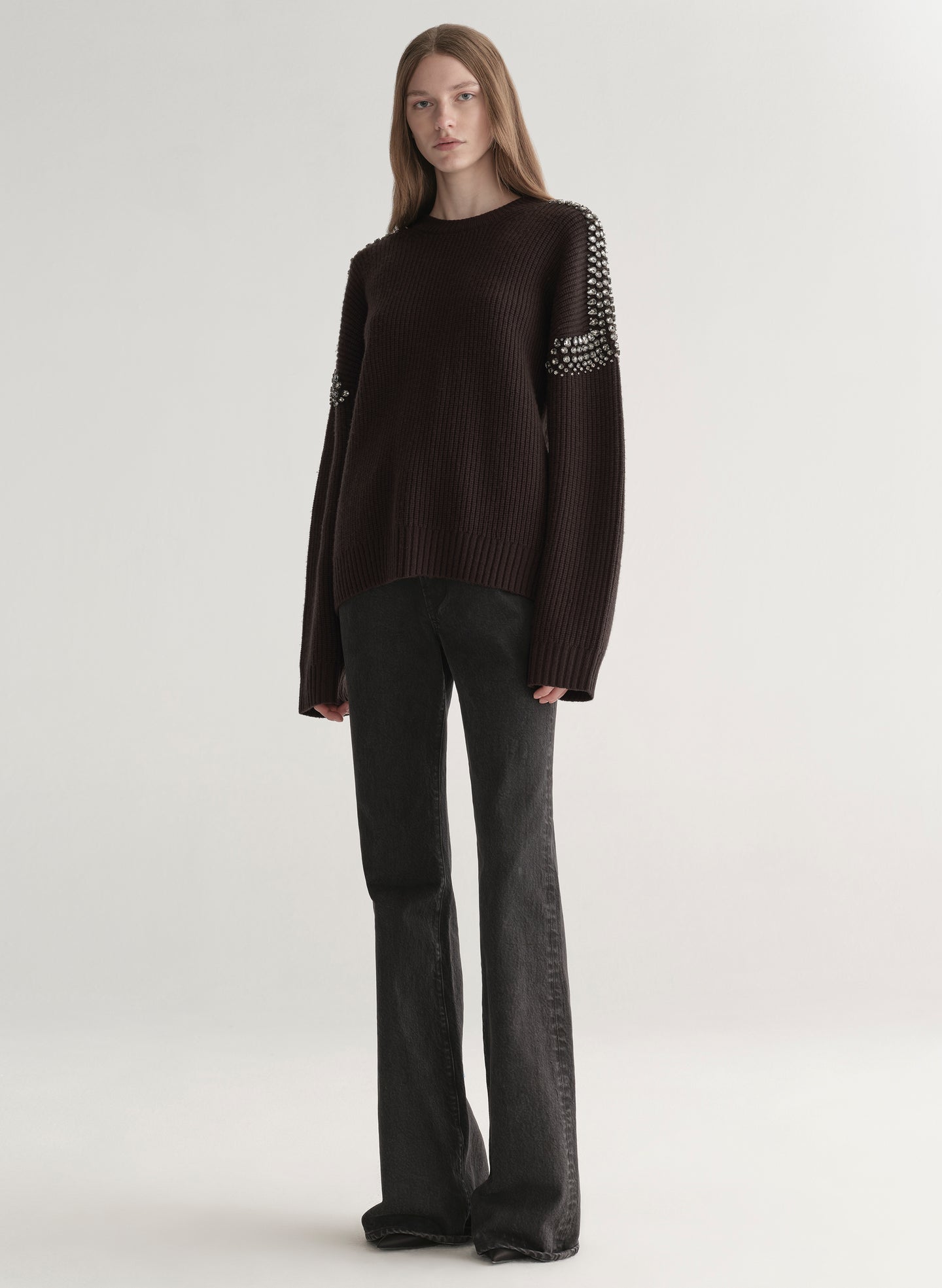 woman wearing brown embellished sweater with black denim jeans