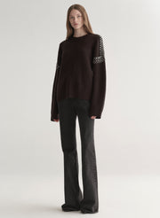 woman wearing brown embellished sweater with black denim jeans