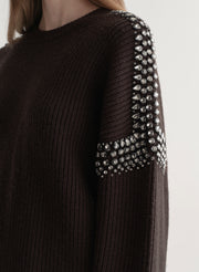 woman wearing brown embellished sweater with black denim jeans