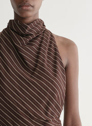 Woman wearing a brown striped top and matching midi skirt against a plain background