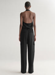 Person wearing a black outfit with open back on a white background