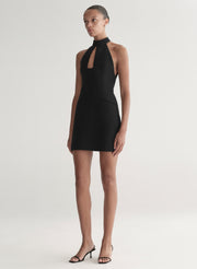 Woman wearing a black halter neck dress on a white background