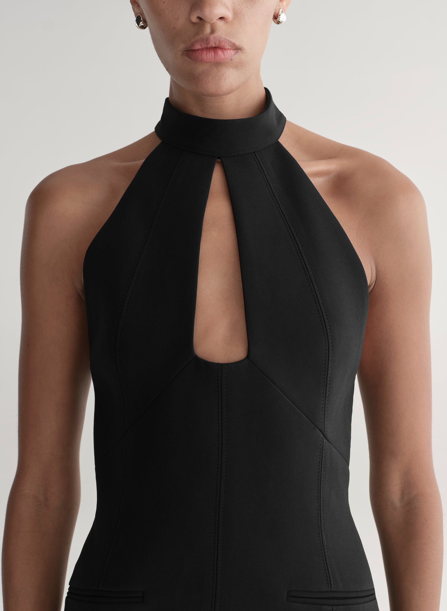 Black halter neck dress worn by a model on a plain background
