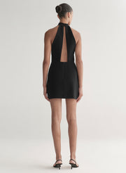 Black halter neck dress with open back on a white background