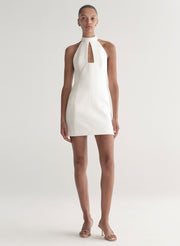White halter neck dress worn by a model on a white background