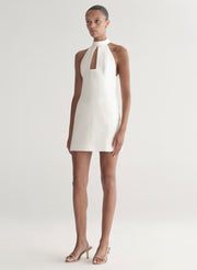 White halter neck dress worn by a model on a white background