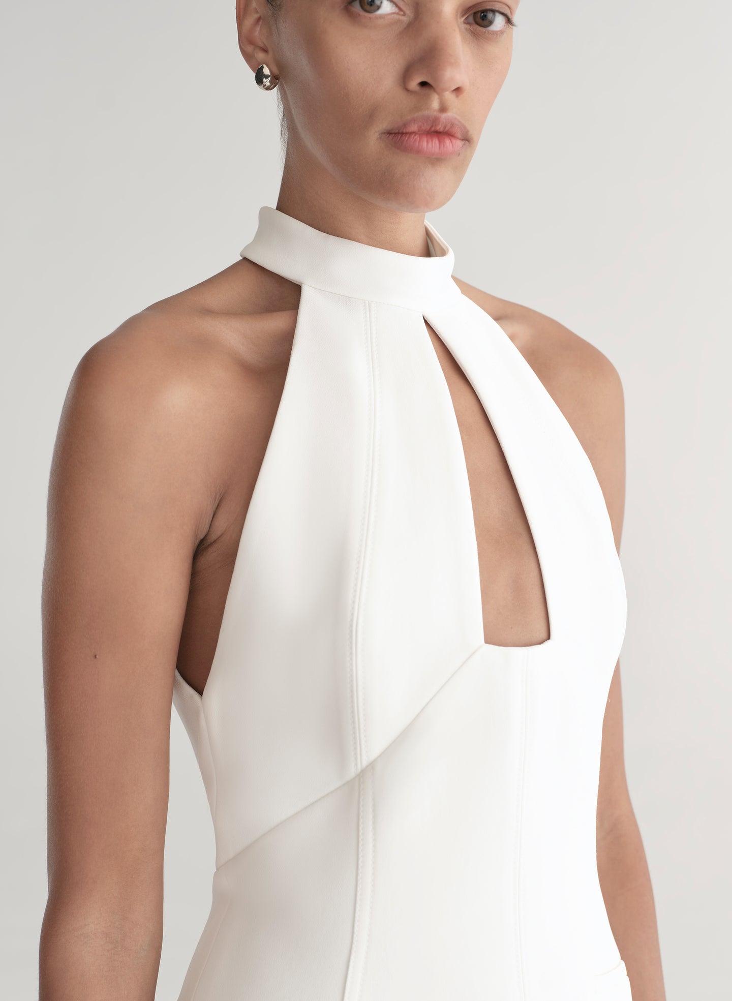 White halter neck dress worn by a model on a white background