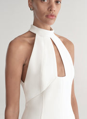White halter neck dress worn by a model on a white background