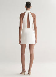 White halter neck dress worn by a model on a white background