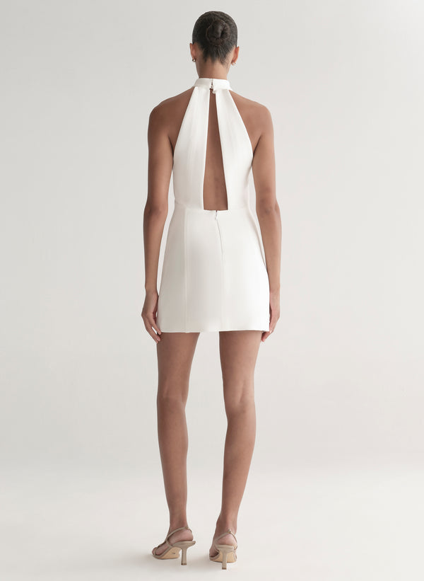 White halter neck dress worn by a model on a white background