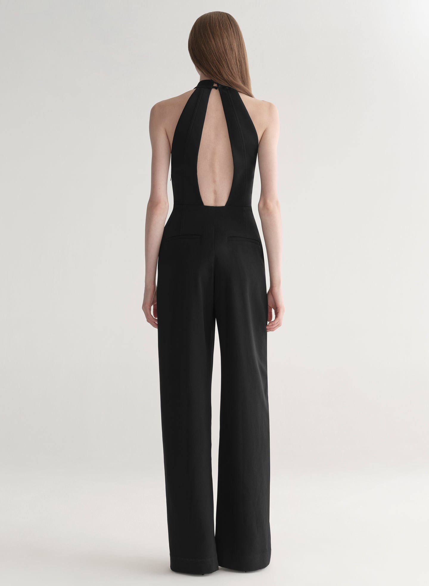 Black jumpsuit with open back on a white background
