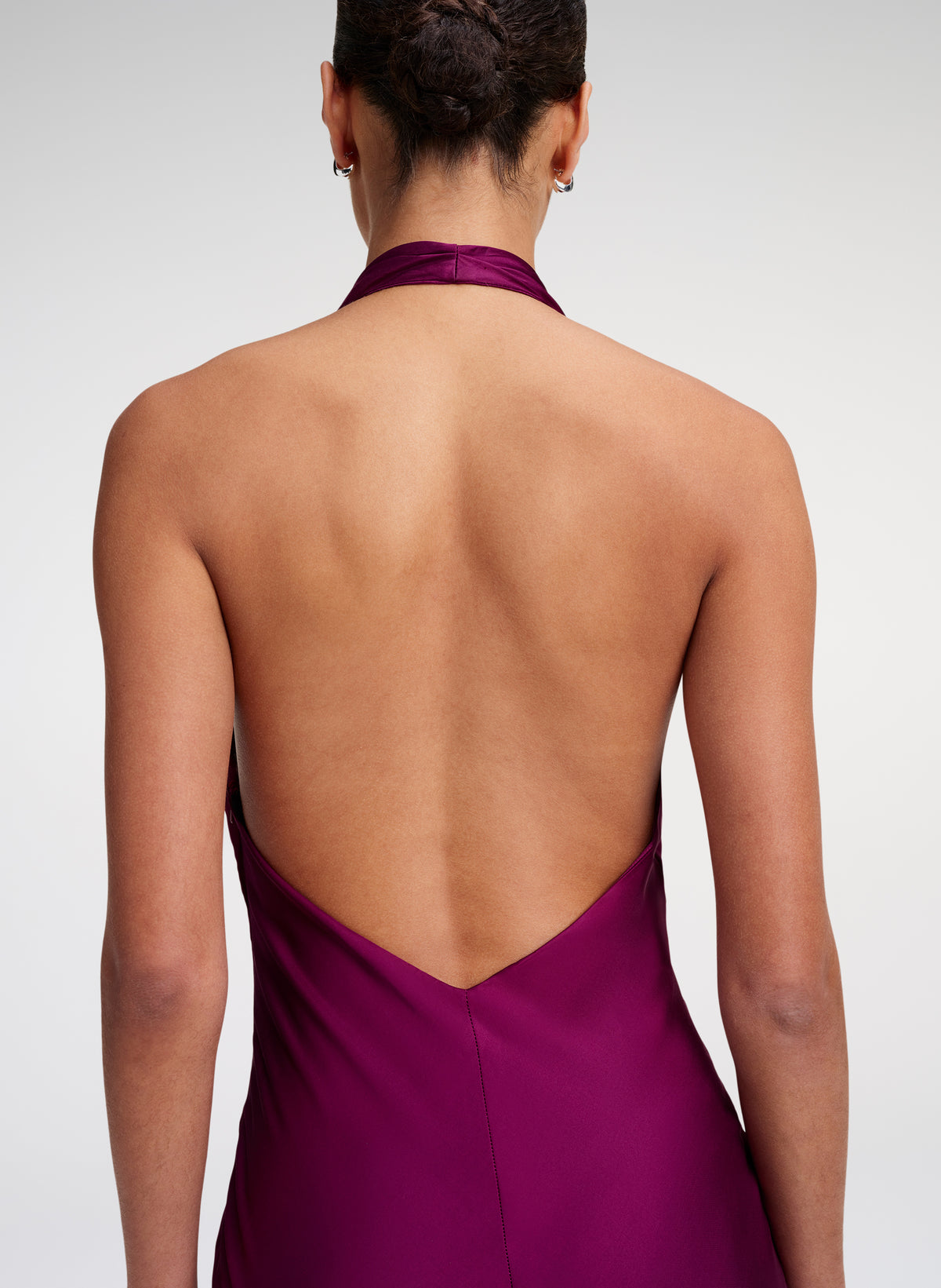 woman wearing an open back gown in a jewel color
