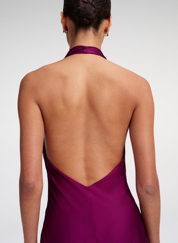 woman wearing an open back gown in a jewel color