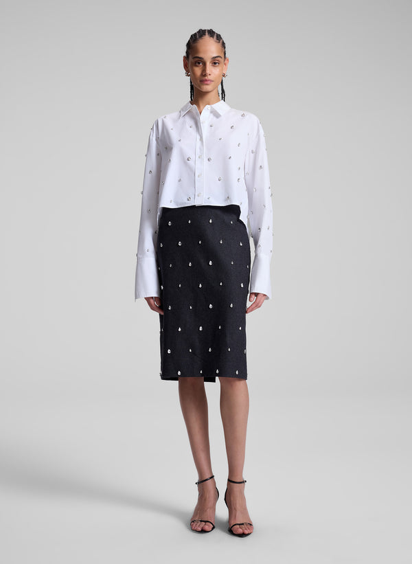 woman wearing white embellished shirt and black embellished skirt