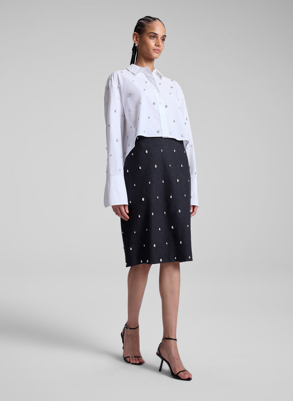 woman wearing white embellished shirt and black embellished skirt