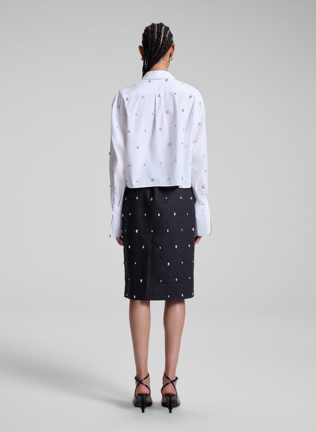 woman wearing white embellished shirt and black embellished skirt