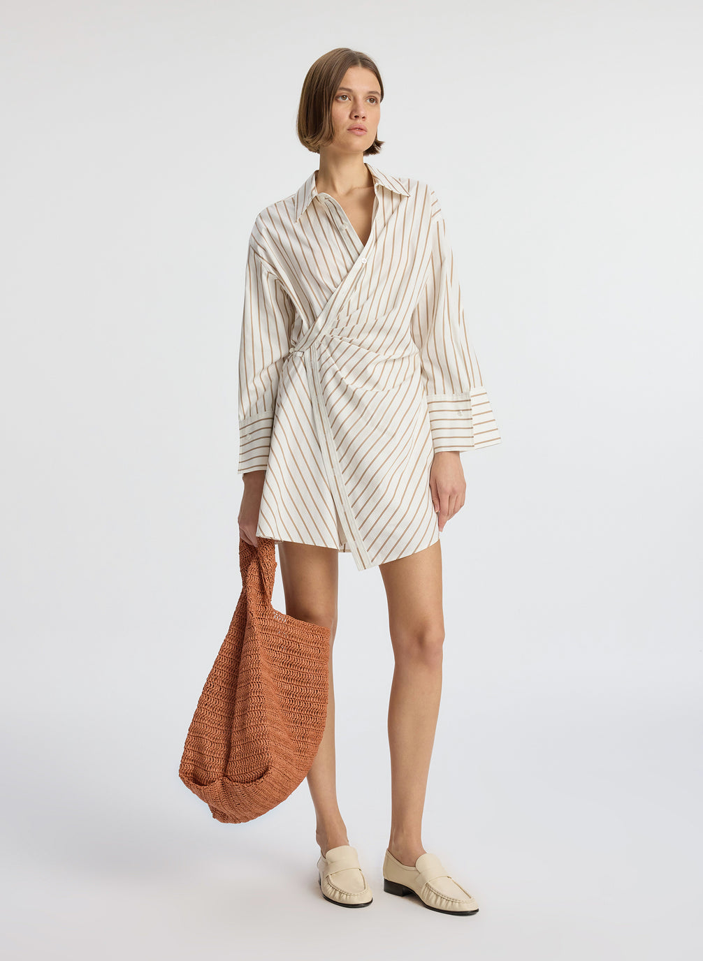 Front view of woman wearing cream and brown striped wrapped shirtdress