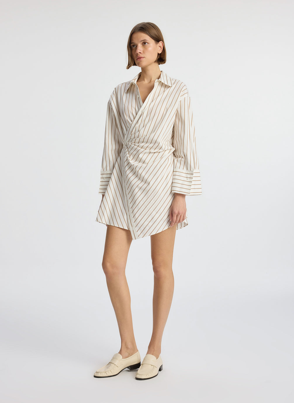 side view of woman wearing cream and brown striped wrapped shirtdress