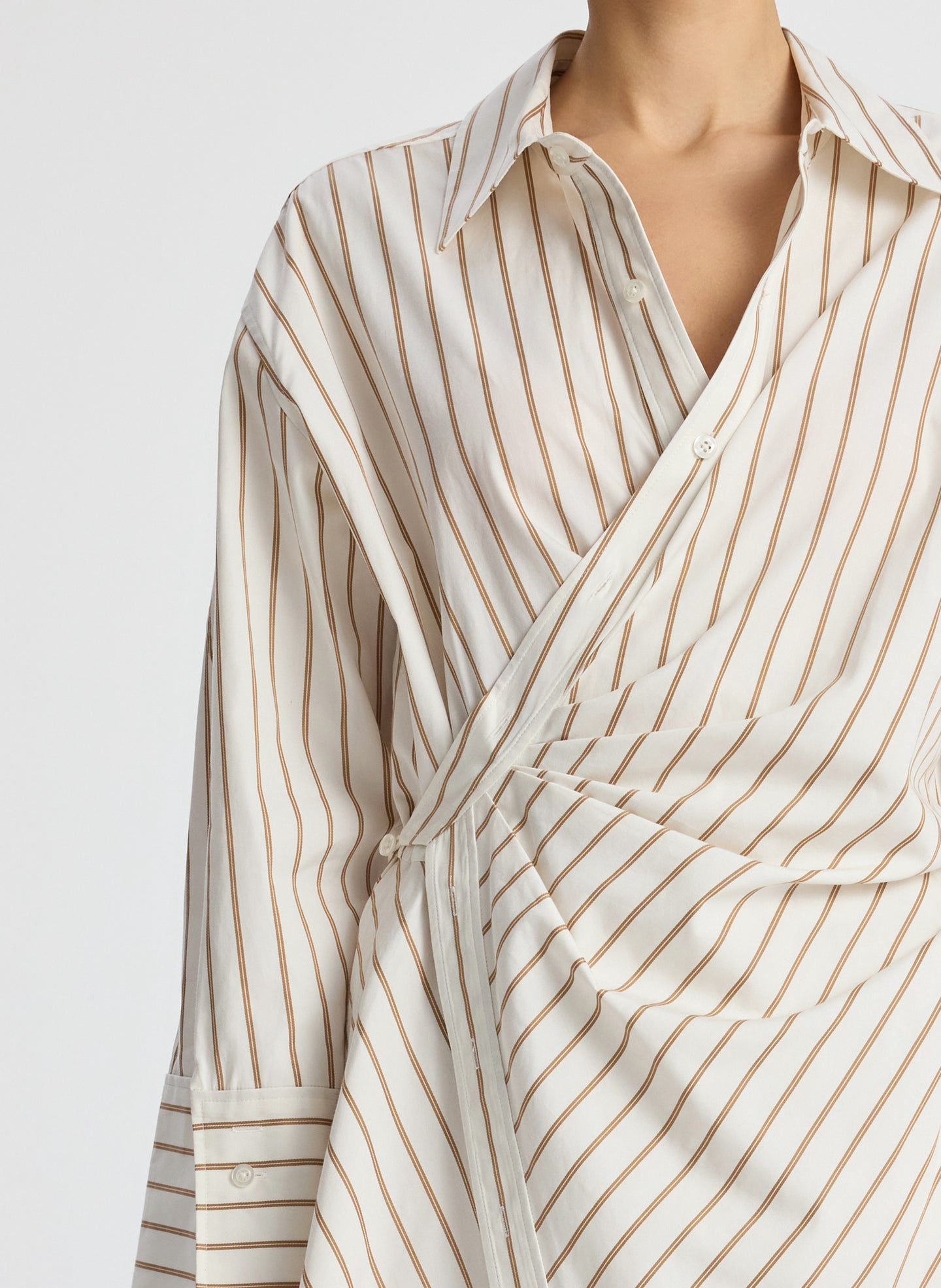 detail view of woman wearing cream and brown striped wrapped shirtdress