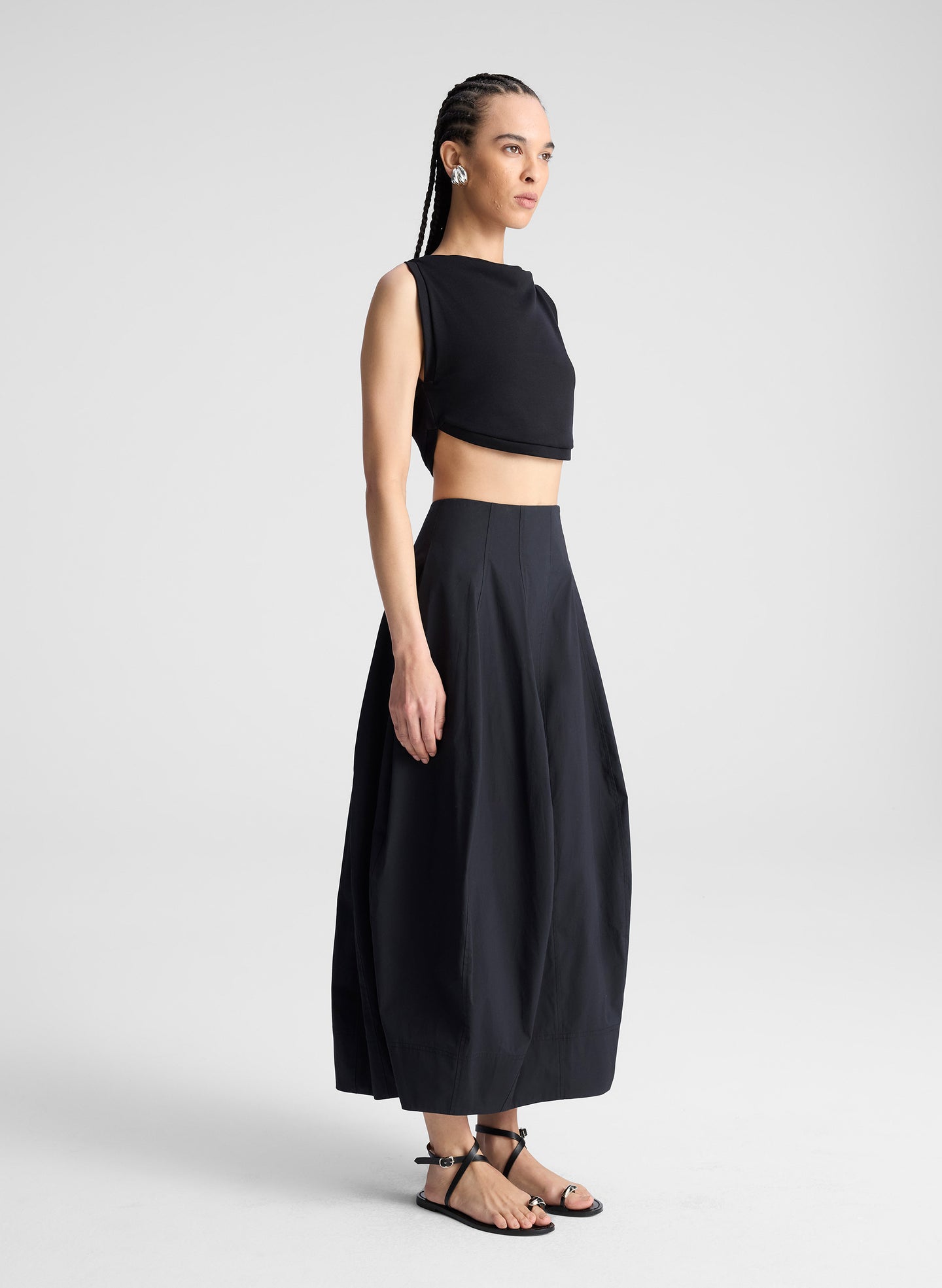 woman wearing black cropped tank and black midi skirt