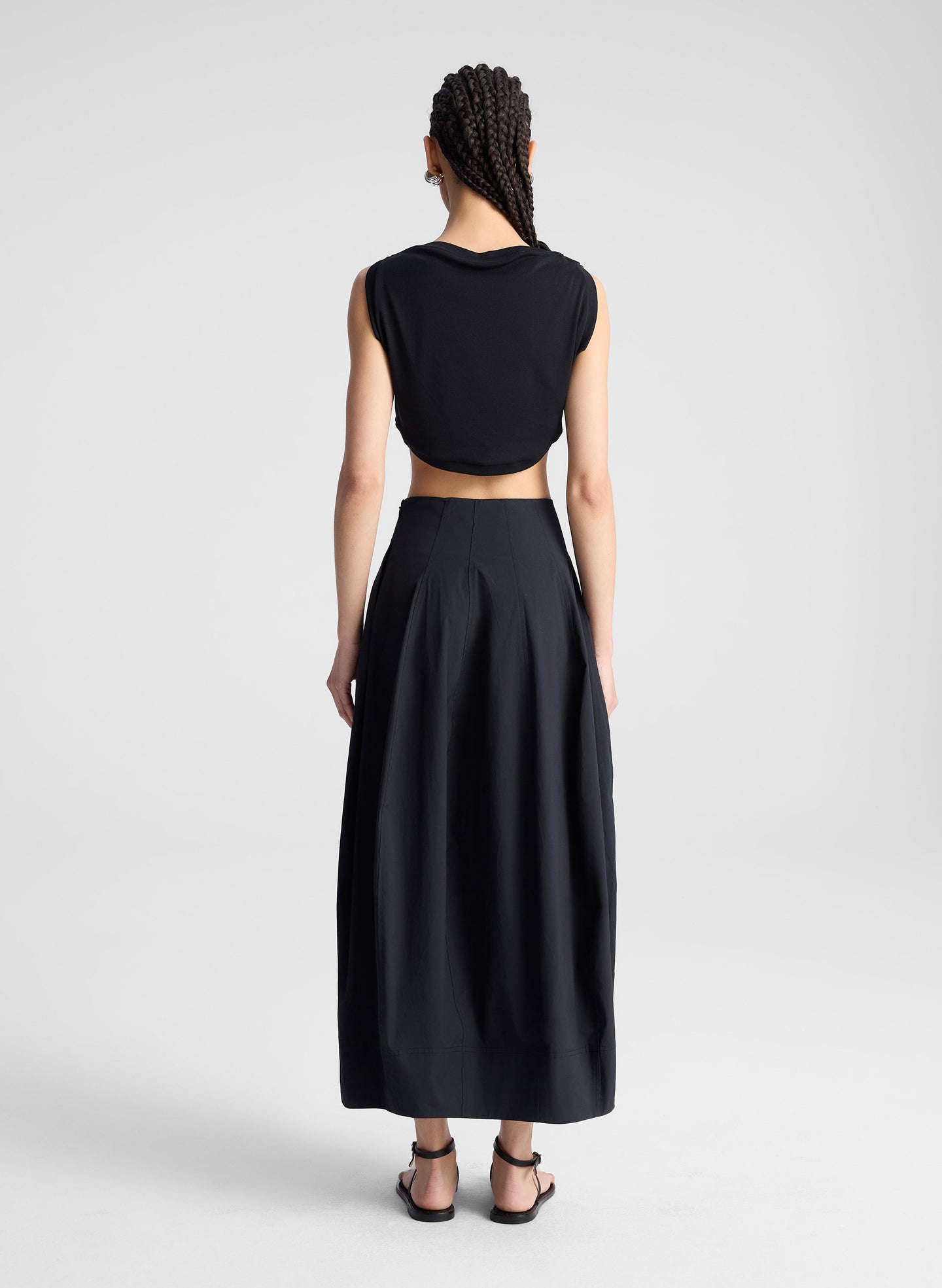 woman wearing black cropped tank and black midi skirt