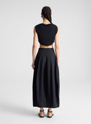 woman wearing black cropped tank and black midi skirt