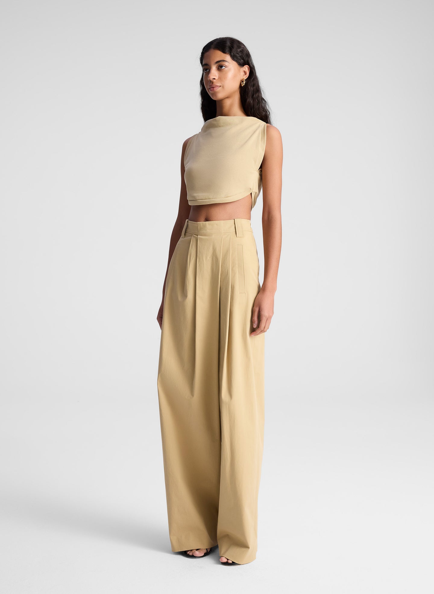 woman wearing beige top and beige draped pants