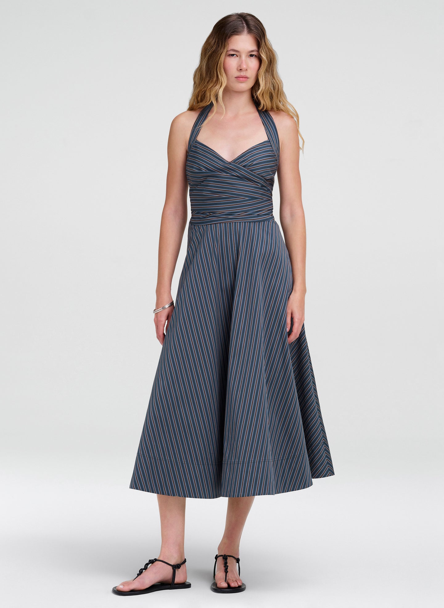 Woman wearing a blue striped dress on a white background