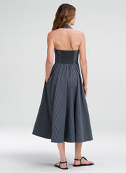 Woman wearing a halter midi striped dress on a white background