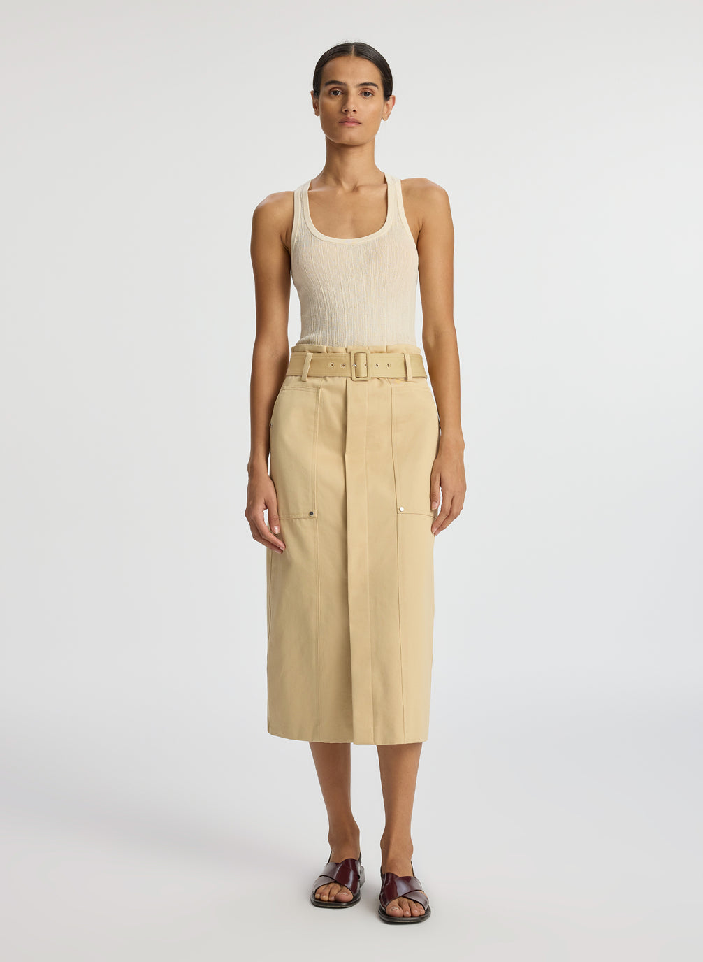 front view of woman wearing beige tank top and tan midi skirt