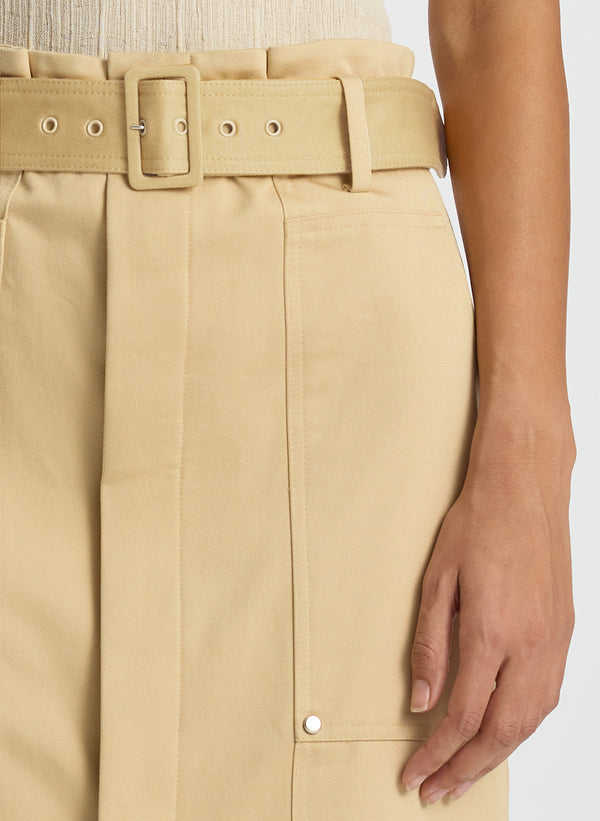 detail view of woman wearing beige tank top and tan midi skirt