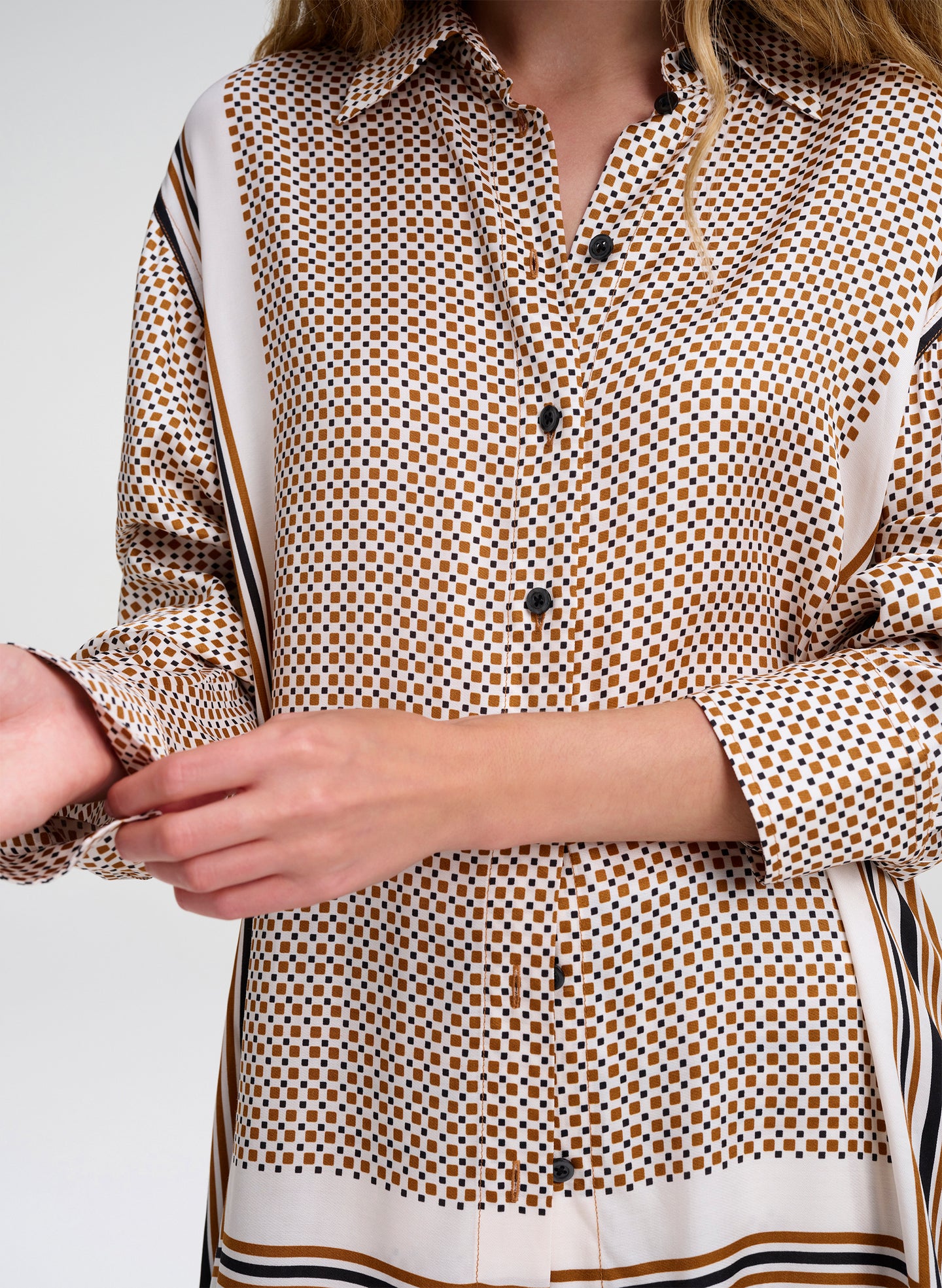 Close-up of a person wearing a patterned shirt with a plain background