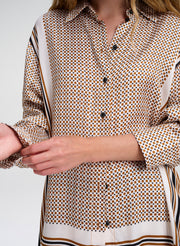Close-up of a person wearing a patterned shirt with a plain background