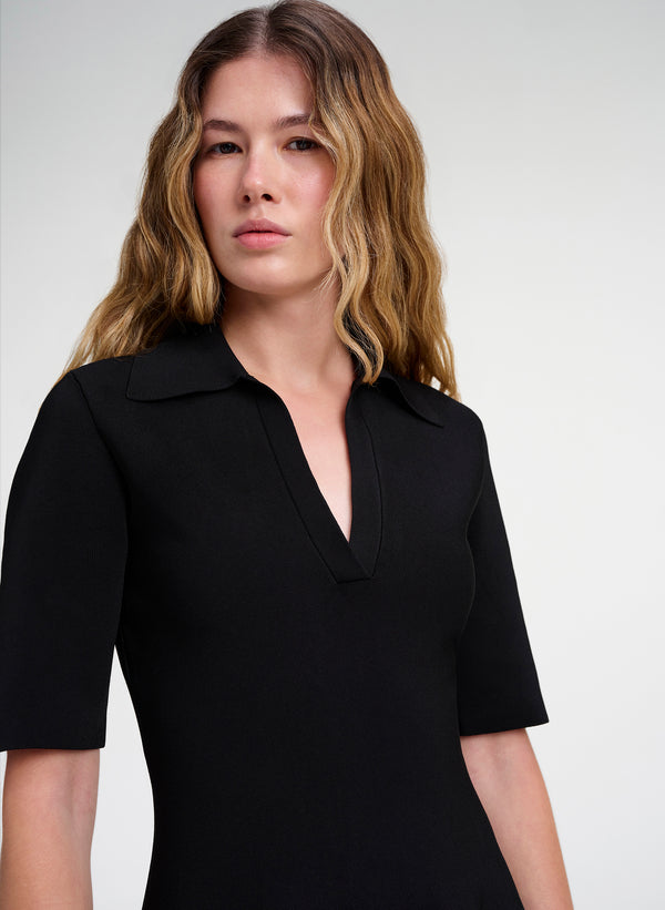 Woman wearing a black dress against a white background