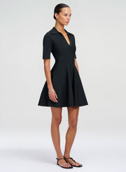 Woman wearing a green mini dress on a white background