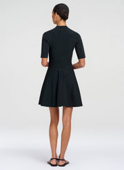 Woman wearing a dark green mini dress on a white background