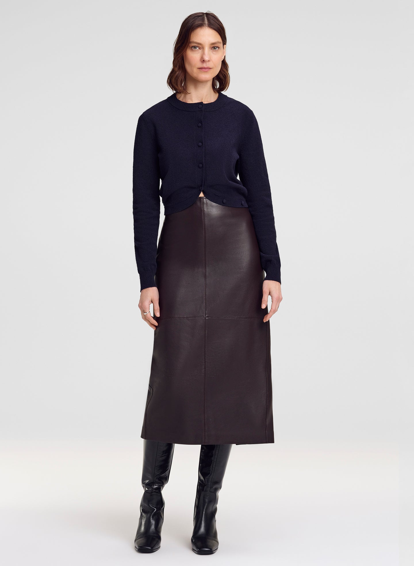 woman wearing navy blue cardigan and brown leather midi skirt