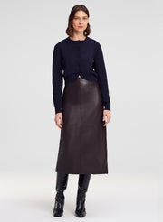 woman wearing navy blue cardigan and brown leather midi skirt