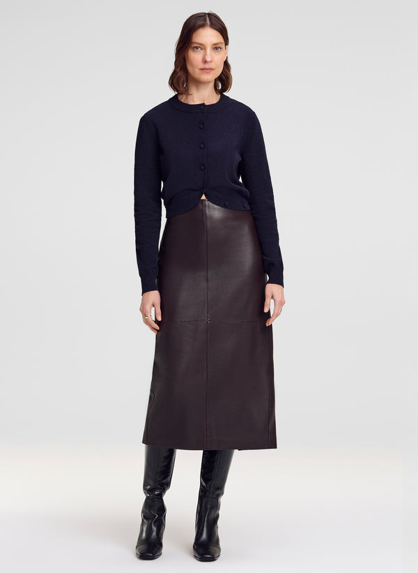 woman wearing navy blue cardigan and brown leather midi skirt
