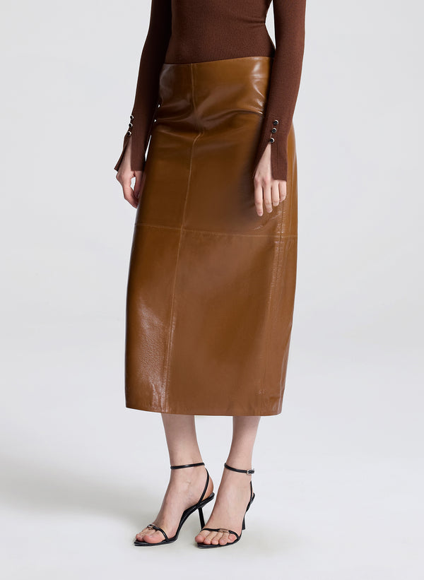 Brown leather skirt worn by a person on a white background