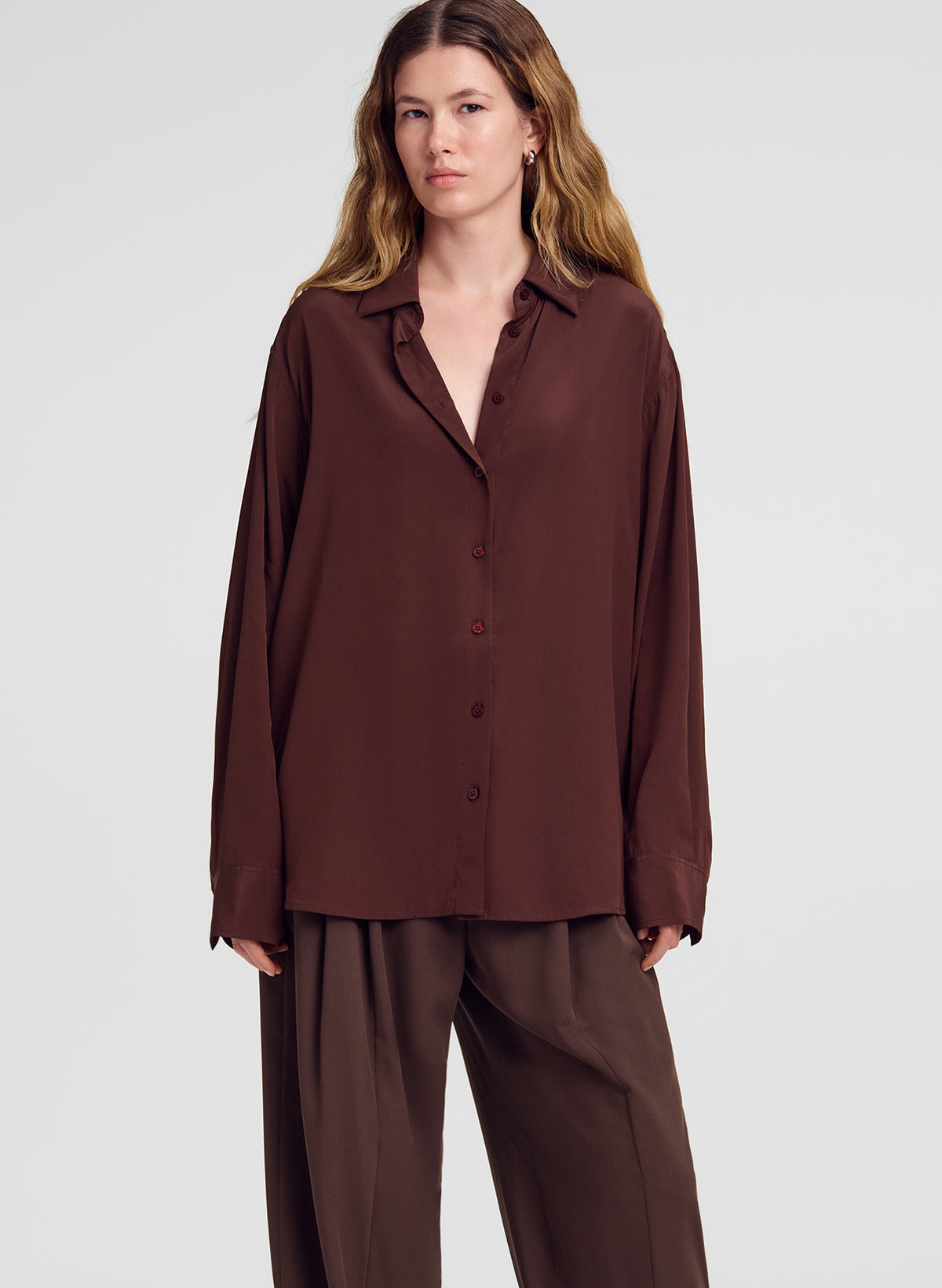 woman wearing brown silk shirt and brown pants