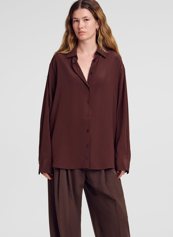 woman wearing brown silk shirt and brown pants