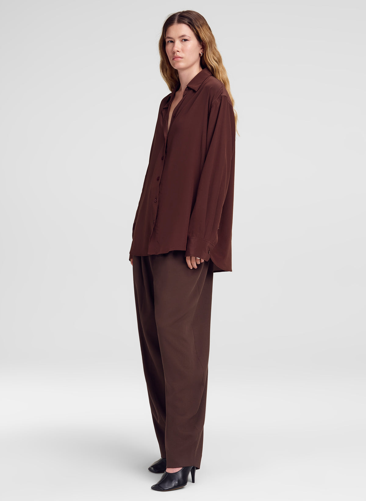 woman wearing brown silk shirt and brown trouser pants