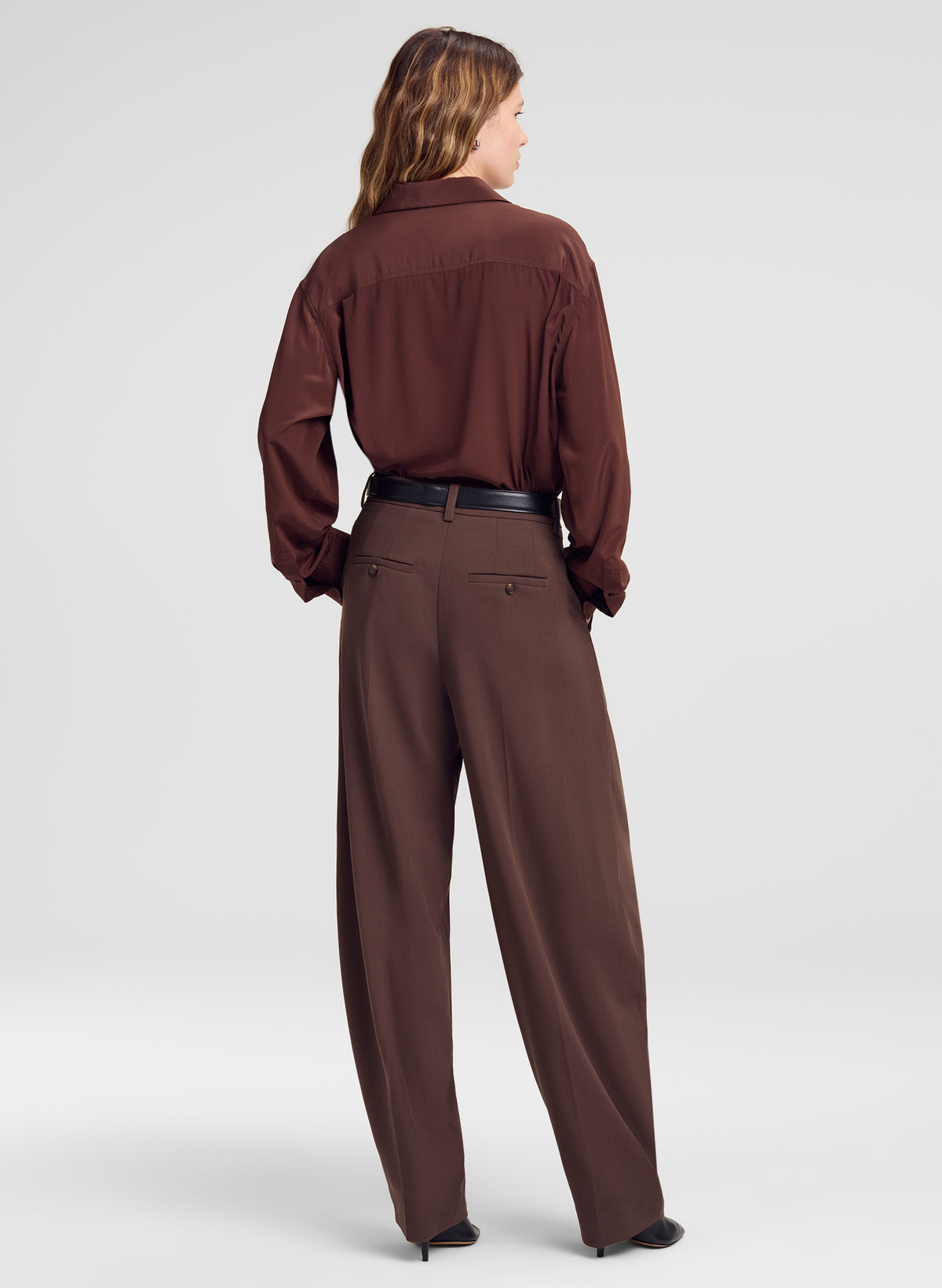 woman wearing brown silk shirt and brown pants