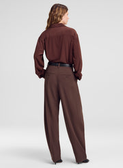 woman wearing brown silk shirt and brown pants